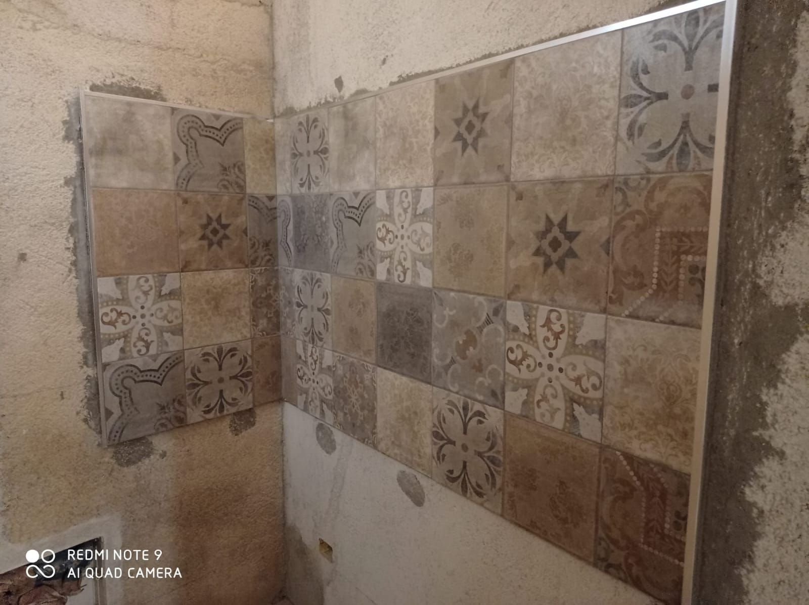un bagno in costruzione con piastrelle su un muro .