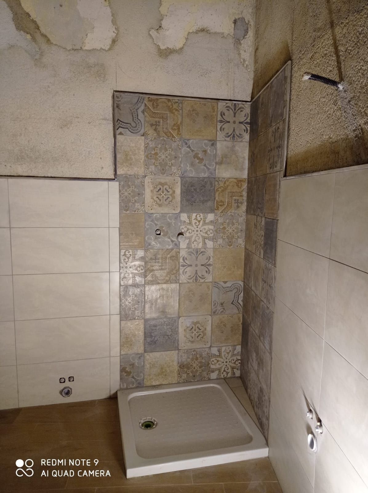 un bagno con doccia e piastrelle sul muro .