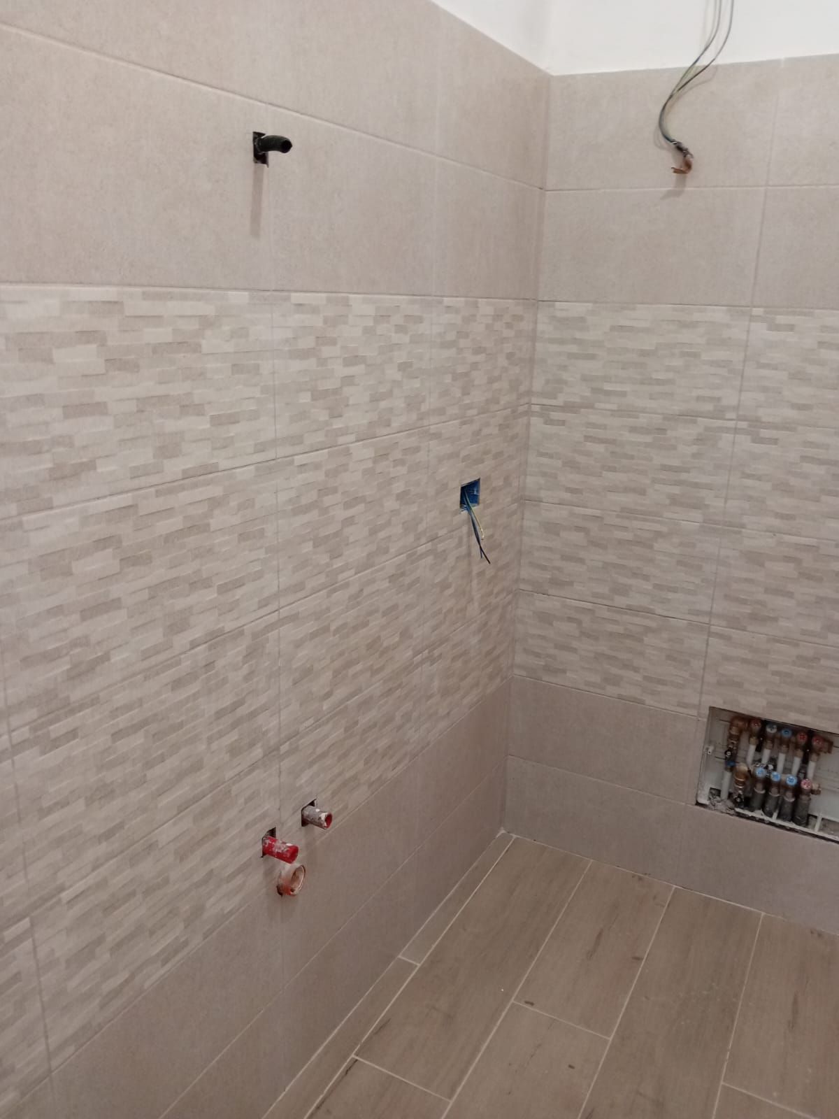 un bagno in costruzione con piastrelle e un pavimento in legno .