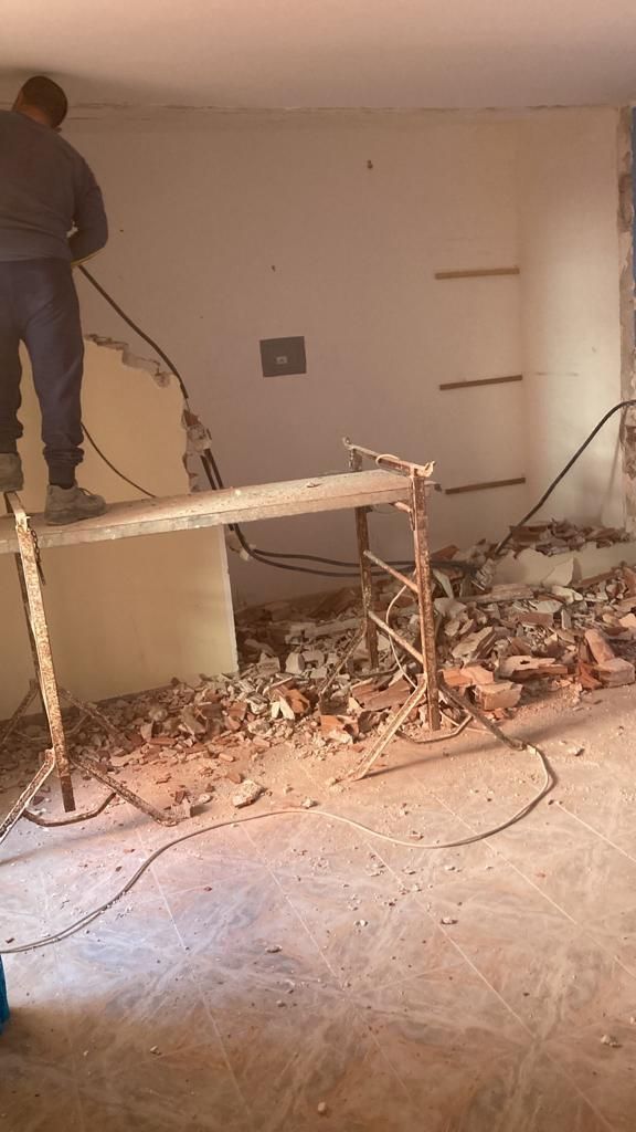 un uomo è in piedi su un escavatore in una stanza .