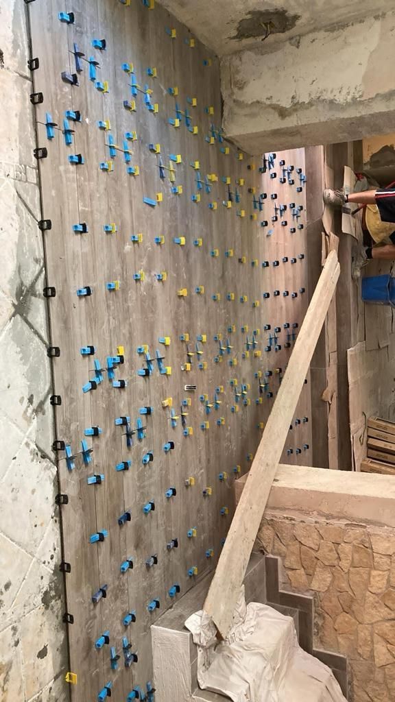 un muro di legno con molti chiodi blu e gialli su di esso .