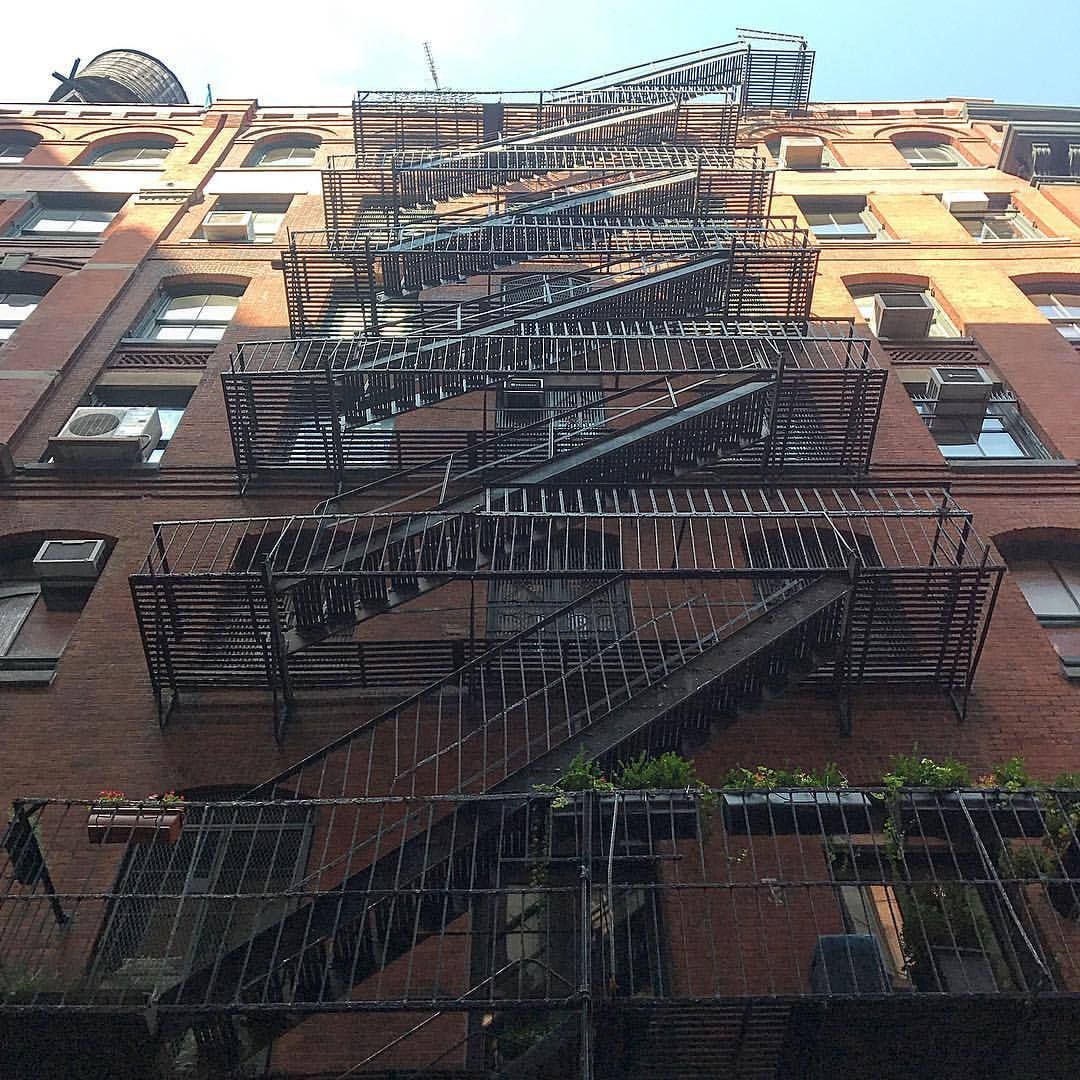 Brick building with a tall, metal fire escape running up the facade.