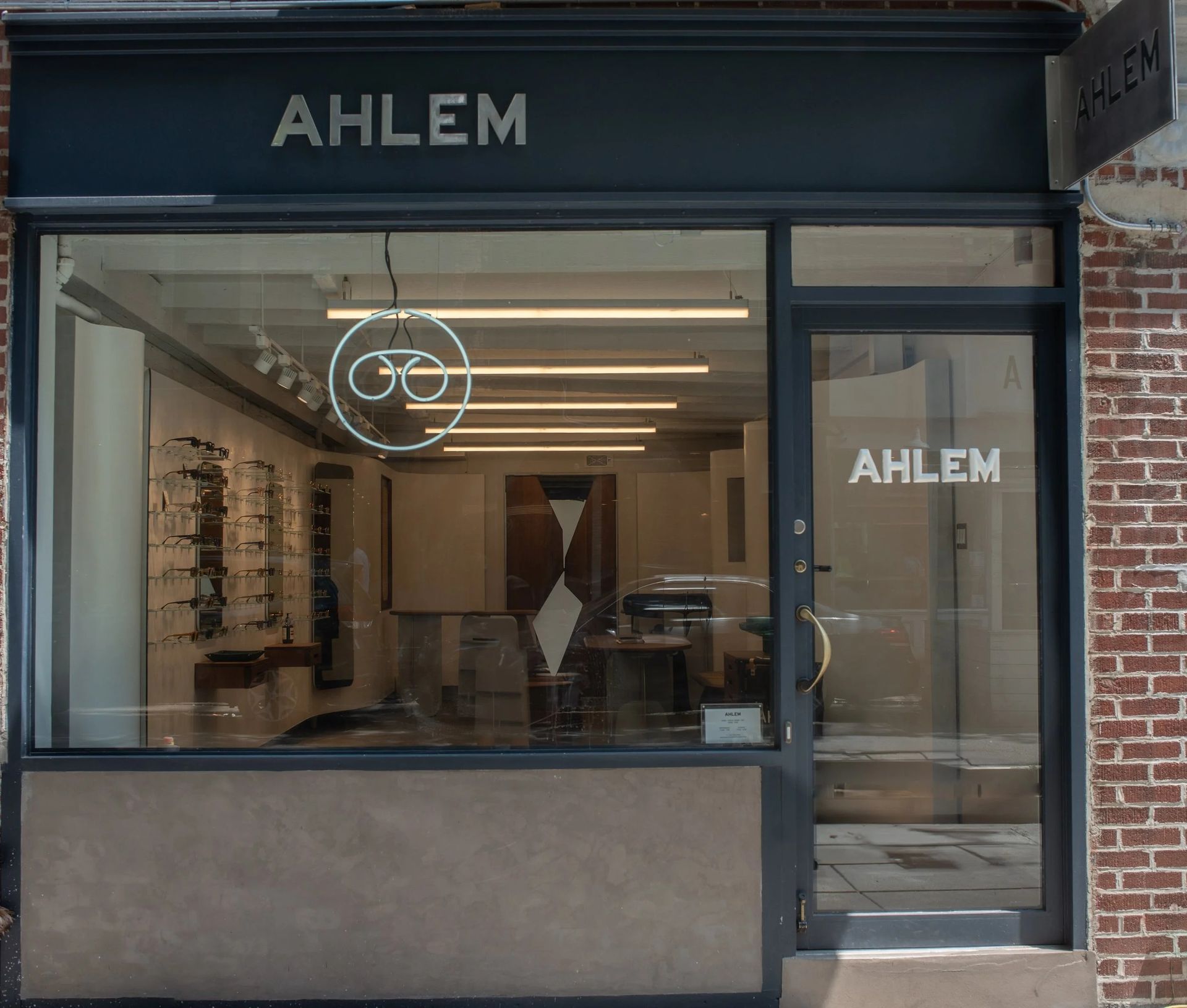 AHLEM eyewear store front with glass windows, sign, and brick building.