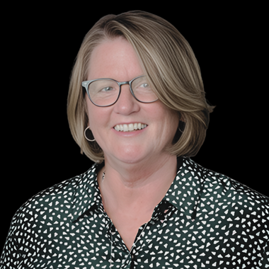 White woman with light brown hair and glasses smiling against a white background