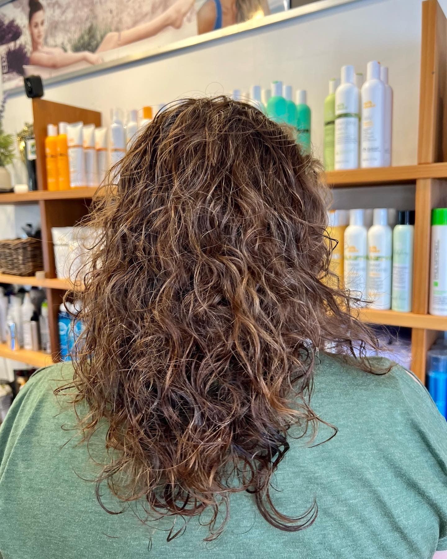 A woman with curly hair is sitting in a salon.