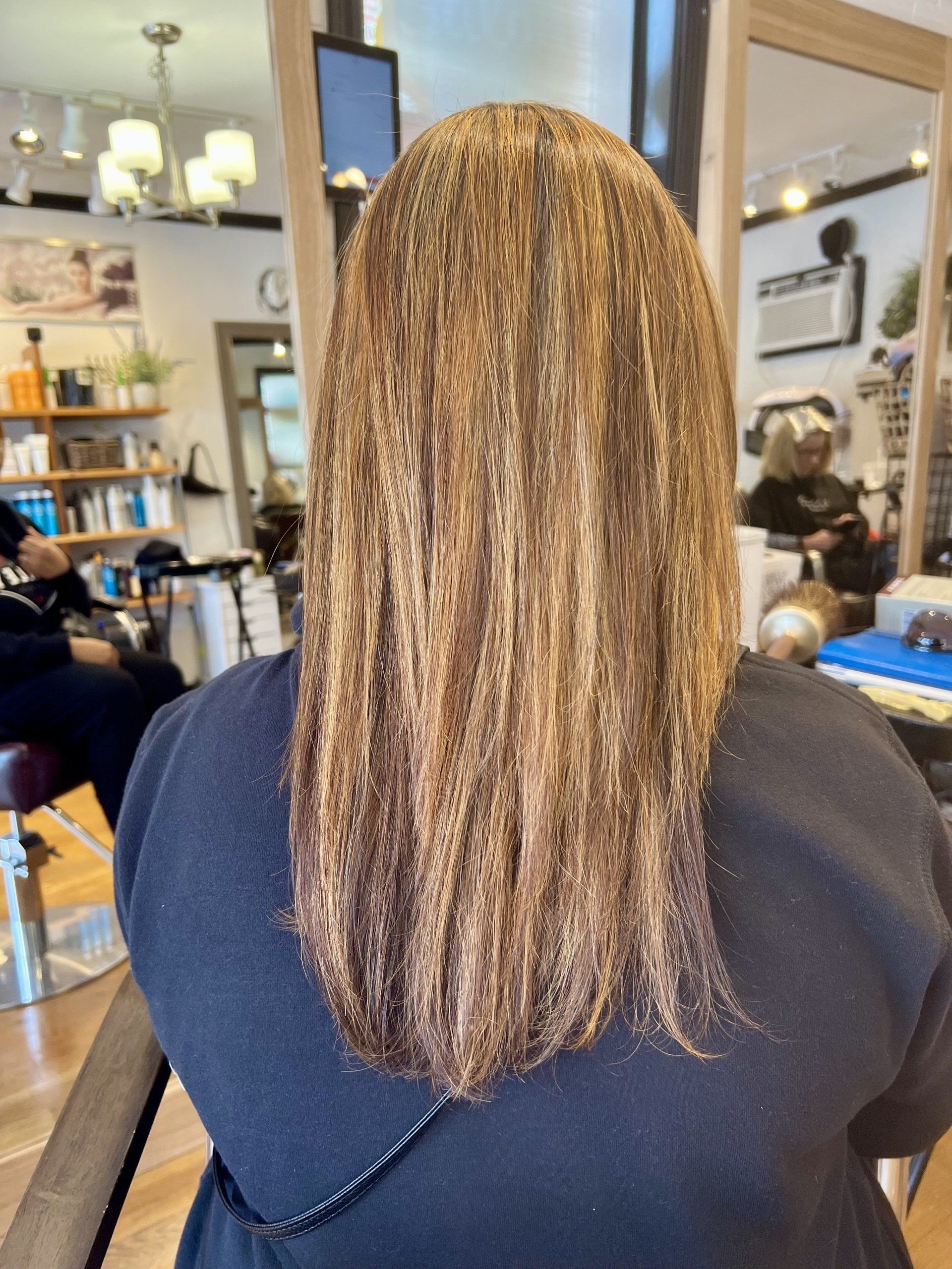 A woman is getting her hair dyed in a salon.