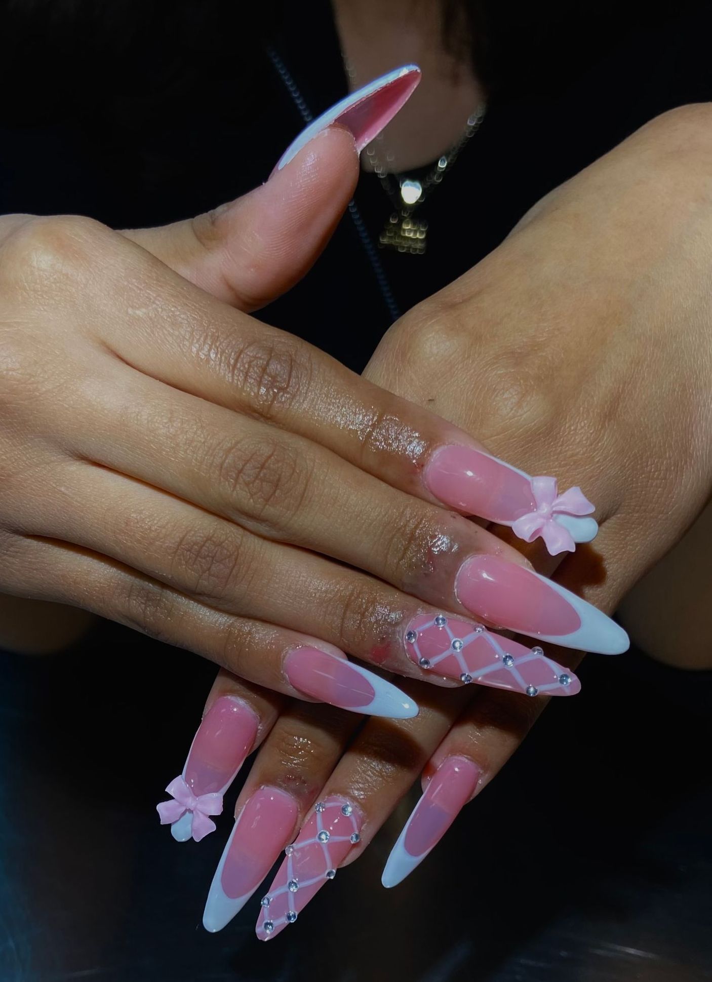 A close up of a woman 's hand with long pink and white nails