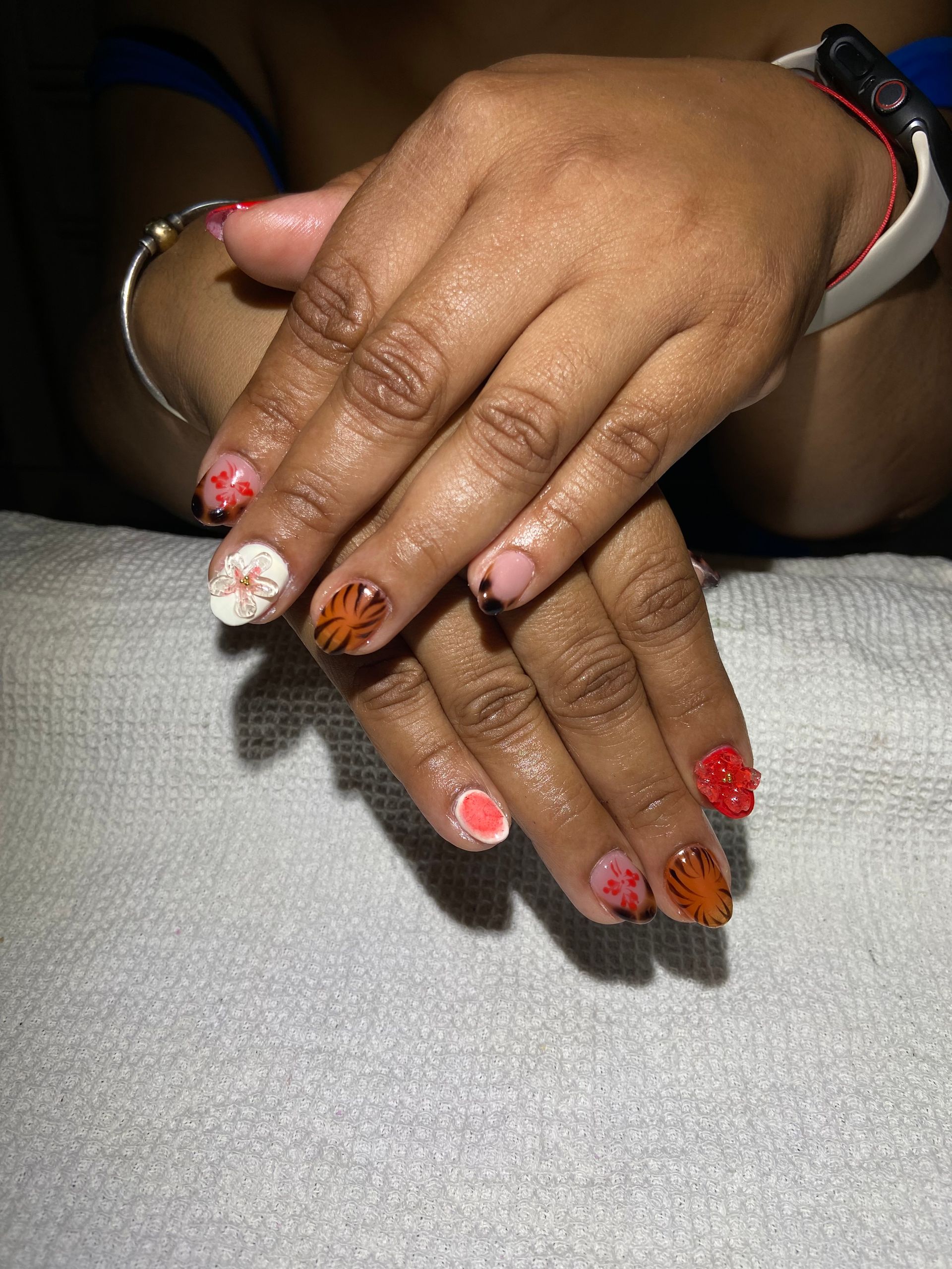 A close up of a person 's nails with a bracelet on their wrist.
