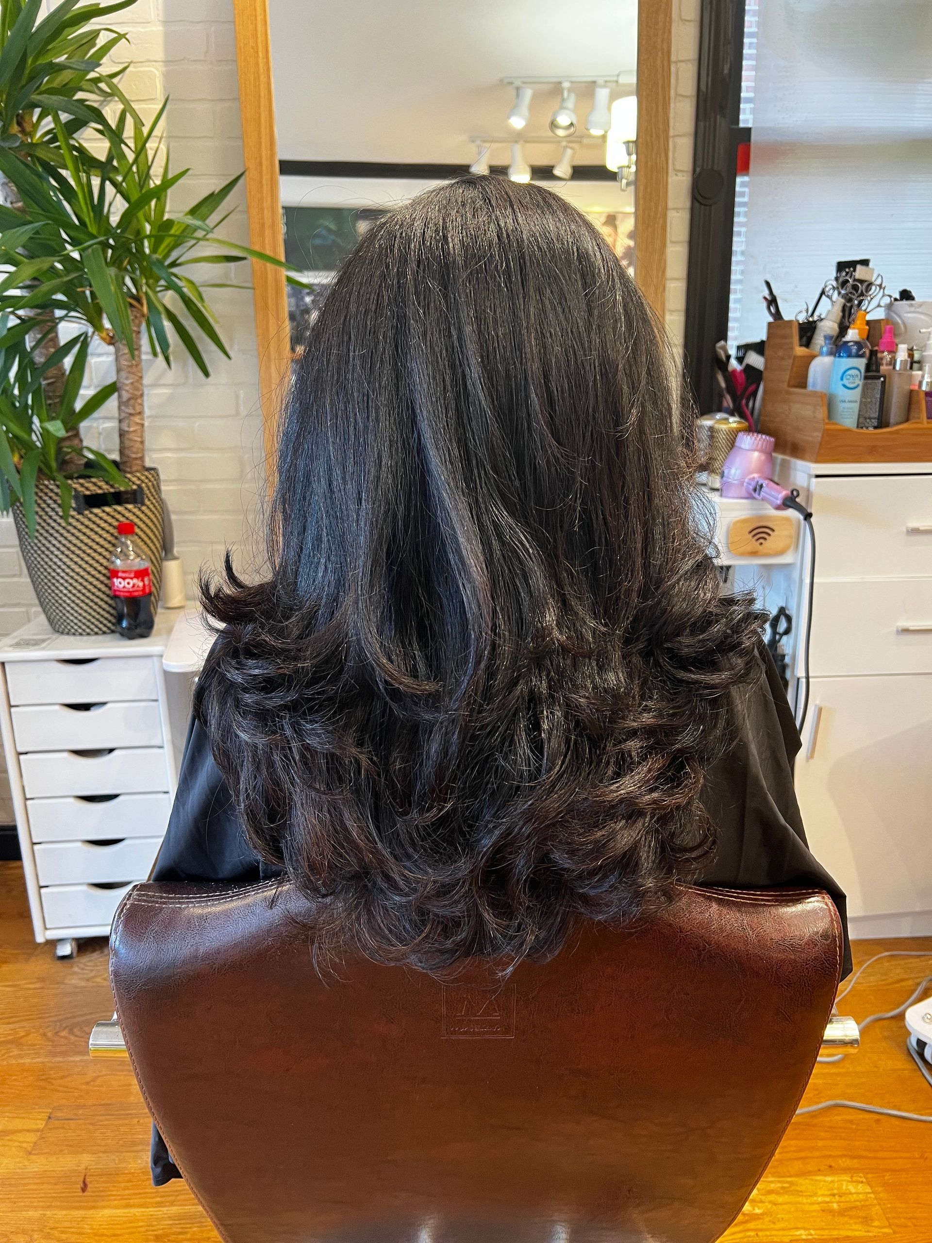 A woman is sitting in a chair with her hair in a salon.