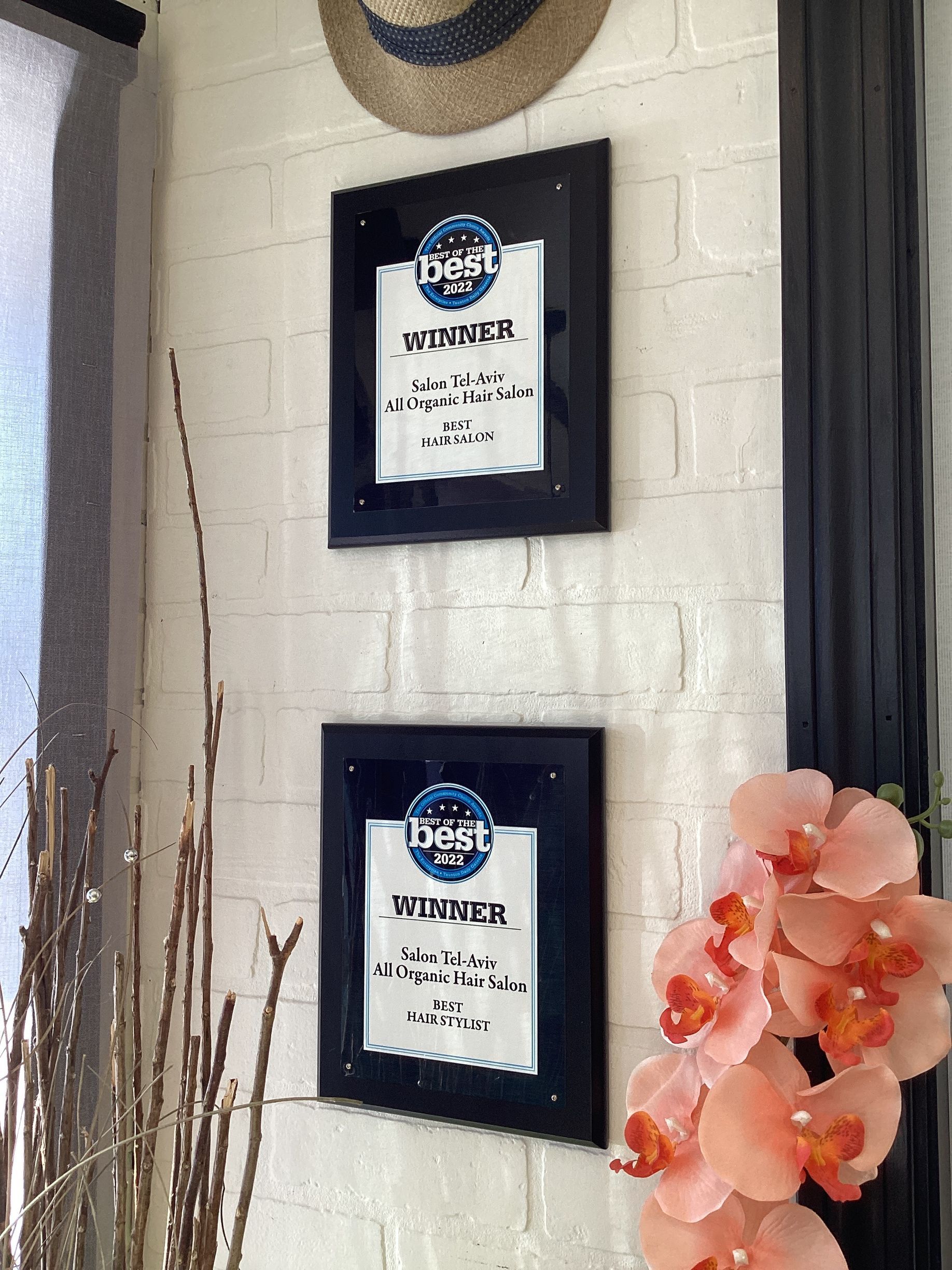 Three framed pictures are hanging on a white brick wall.