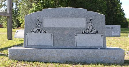 A grave in a cemetery with a cross on it