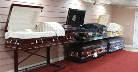 A row of coffins are sitting on a table in a room.