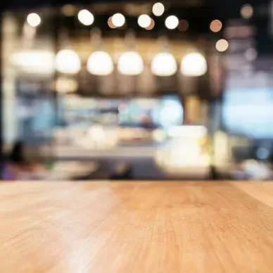 A wooden table with a blurry background of a restaurant.