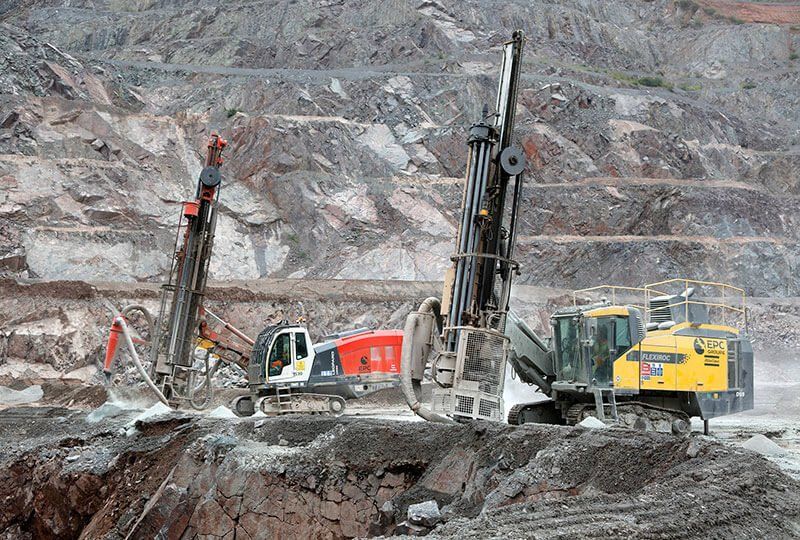 A group of construction vehicles are working in a quarry.