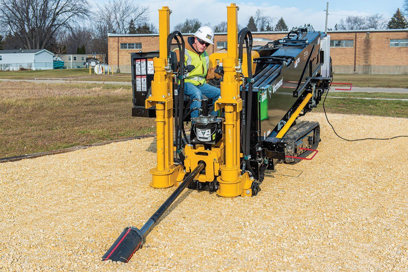 A man is sitting on a machine in a field.