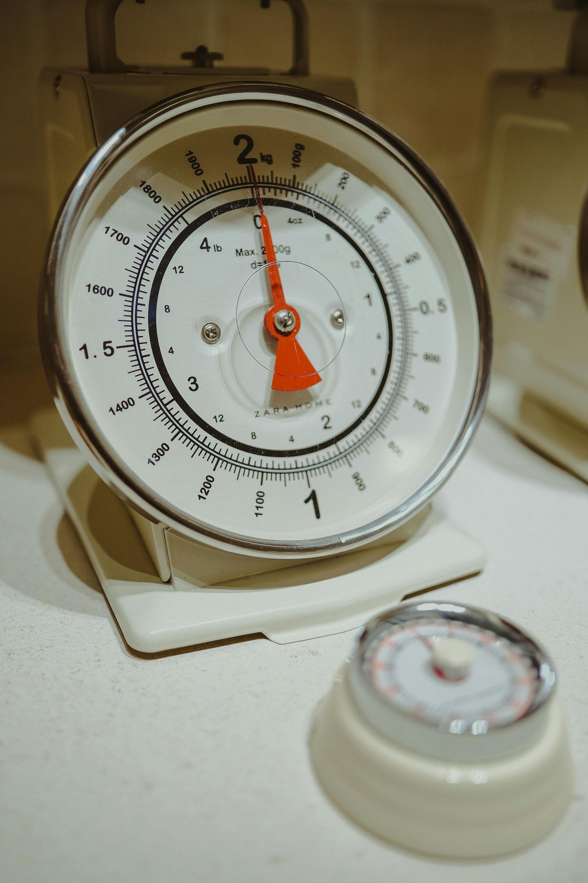 Bilancia da cucina bianca con lancetta rossa che indica il 2.