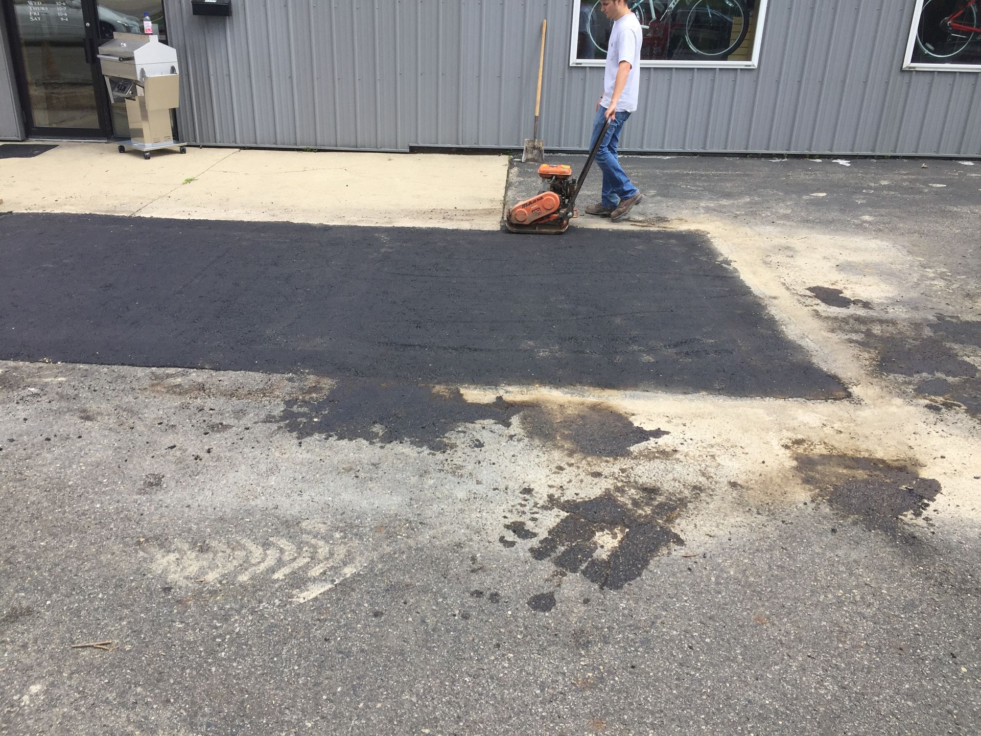 A man is walking down a road with a vacuum cleaner.