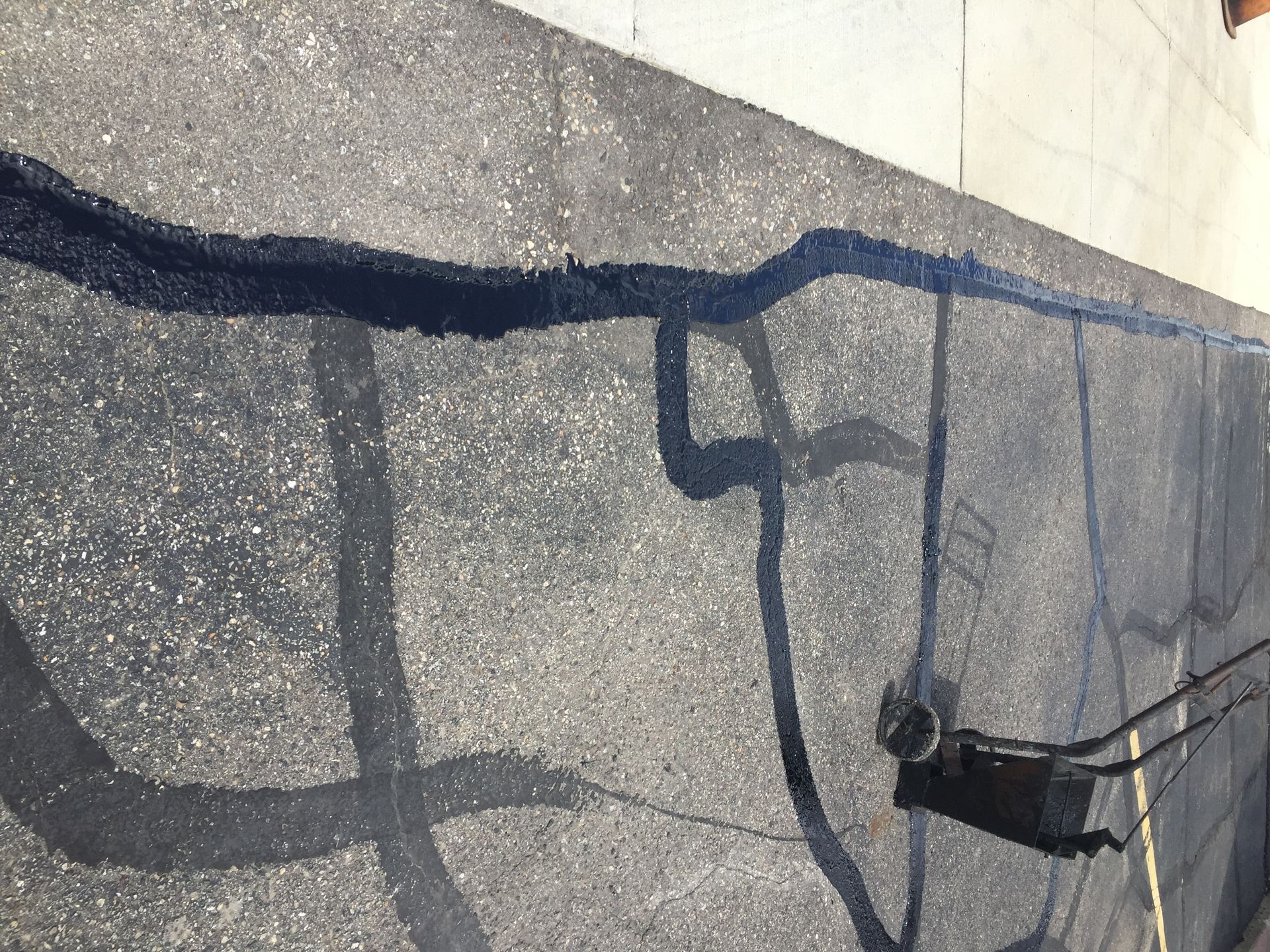 A person is painting graffiti on the side of a road.