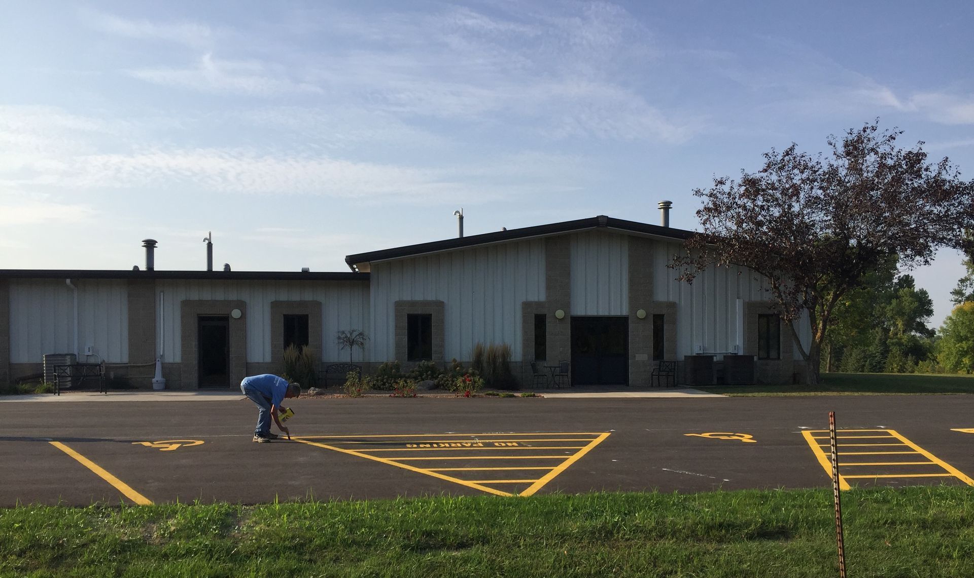 A man is using a machine to paint lines in a parking lot