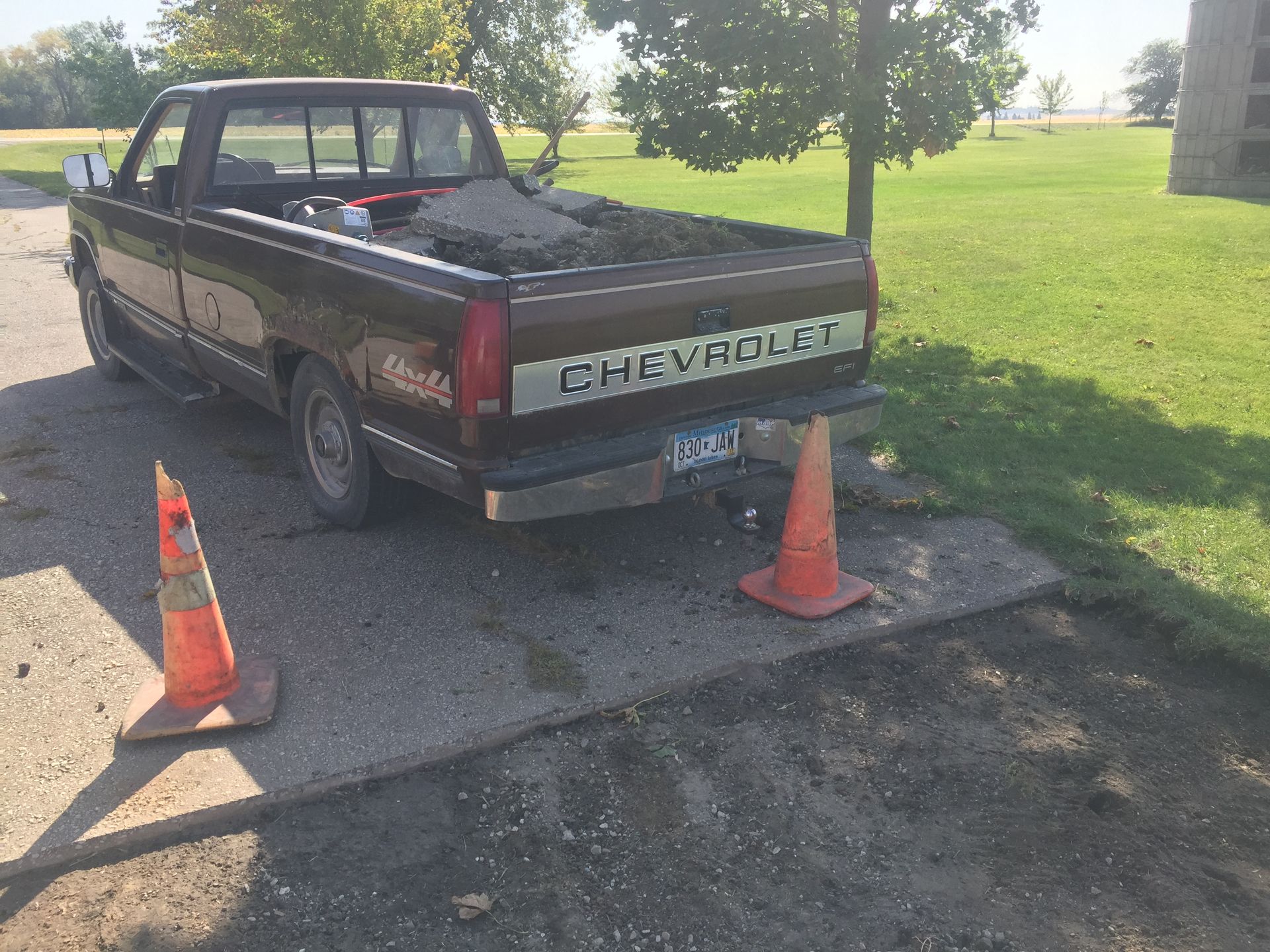 A brown chevrolet truck is parked on the side of the road