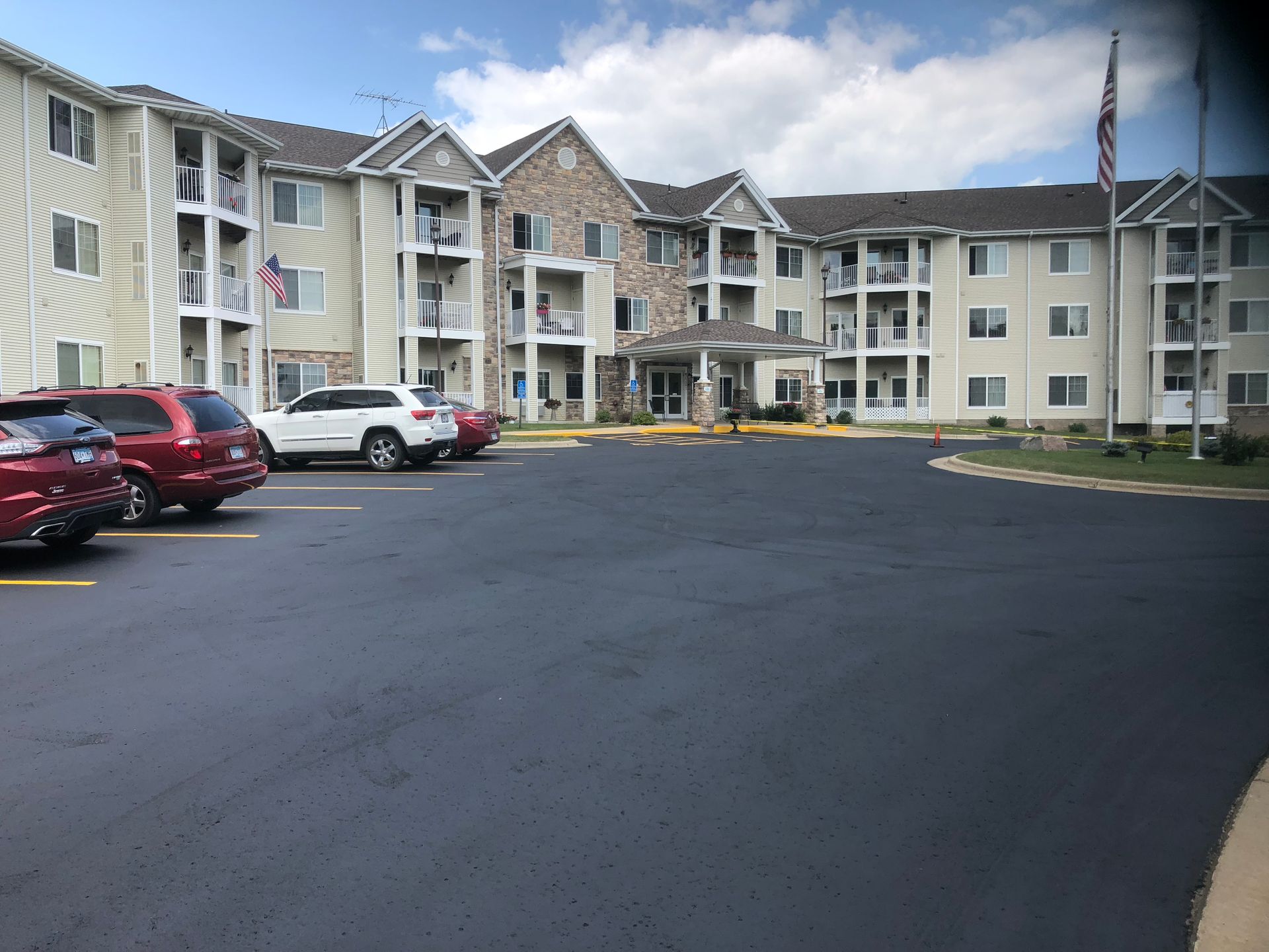 A red truck is driving down a road with a trailer attached to it.