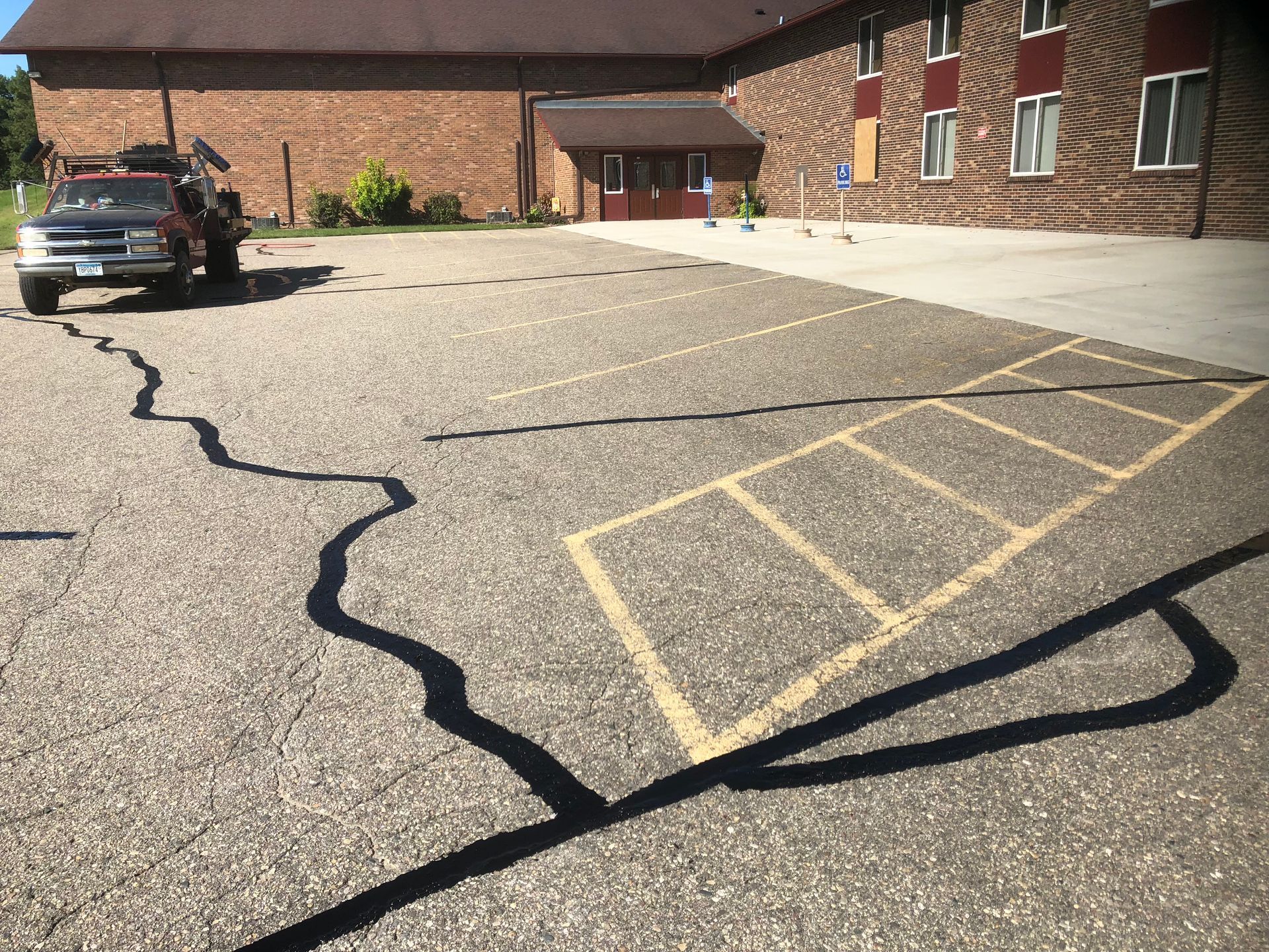 A truck is parked in a parking lot in front of a brick building.