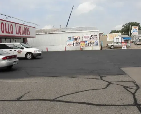 A liquor store with cars parked in front of it