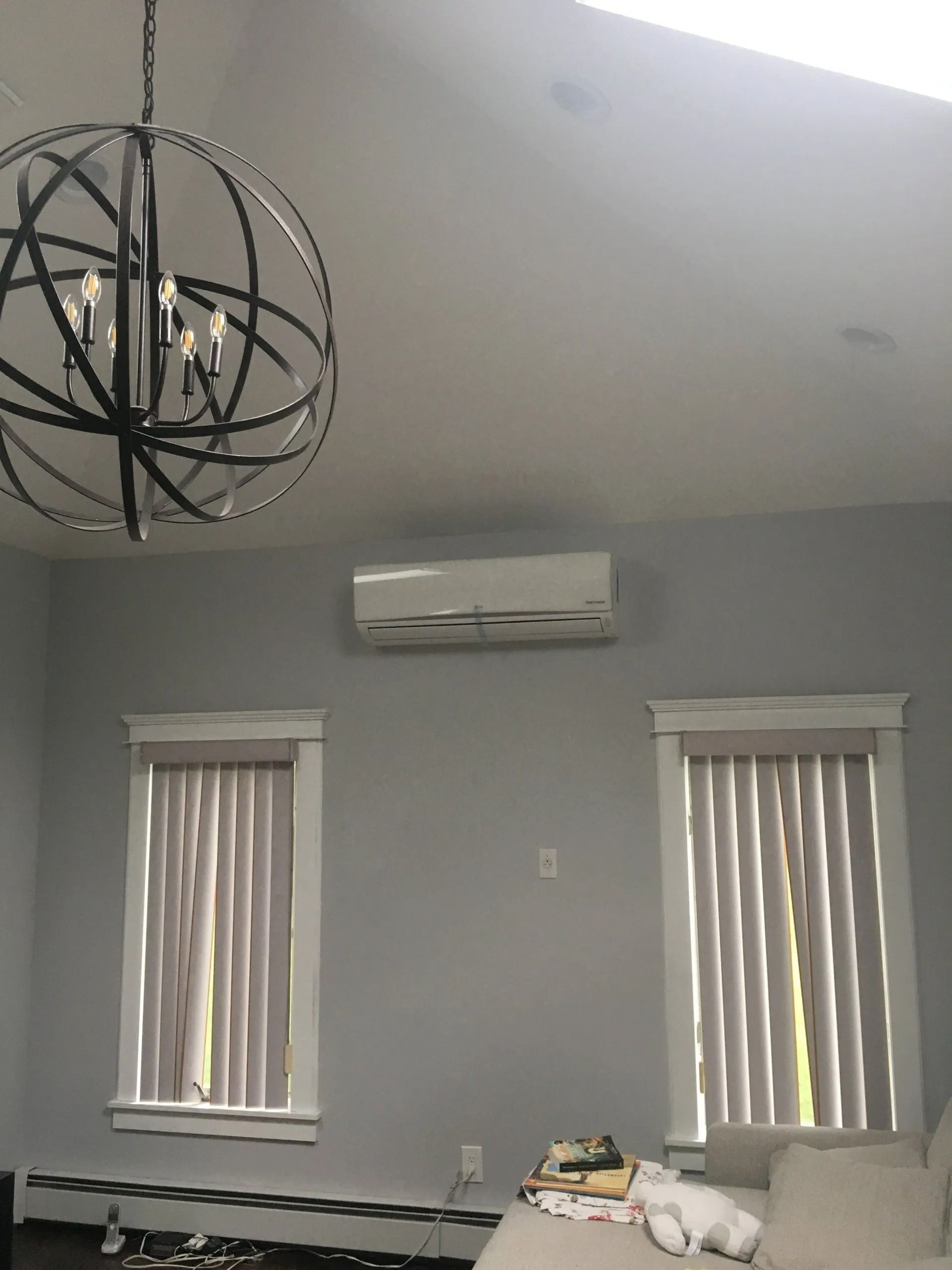 Gray room with two windows, an air conditioner, and an orb chandelier.