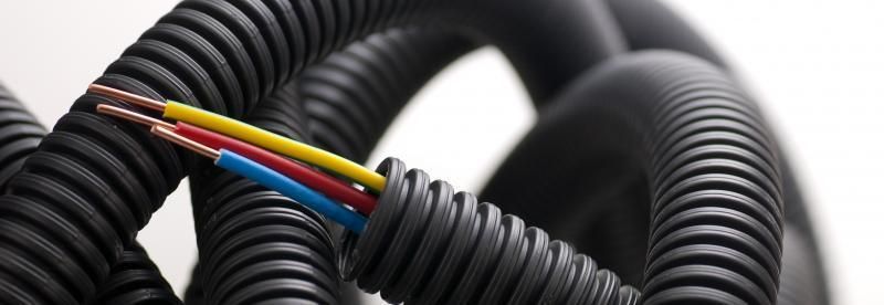 Electrical wires bundled in black corrugated tubing. Wires are brown, yellow, red, and blue.
