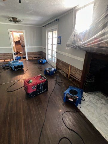 Room with several dehumidifiers drying the floor after possible water damage.