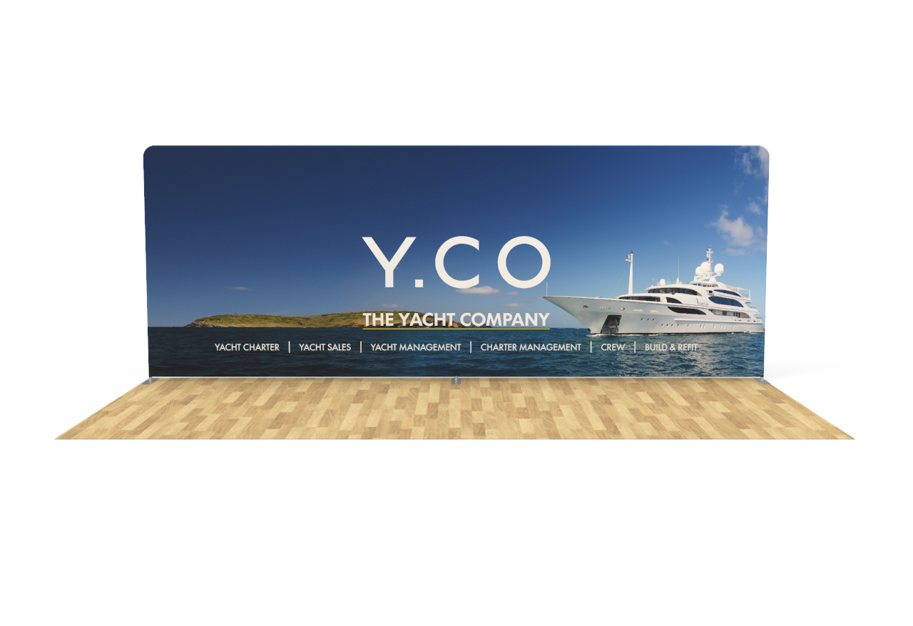 A banner for y.co the yacht company is sitting on a wooden floor.