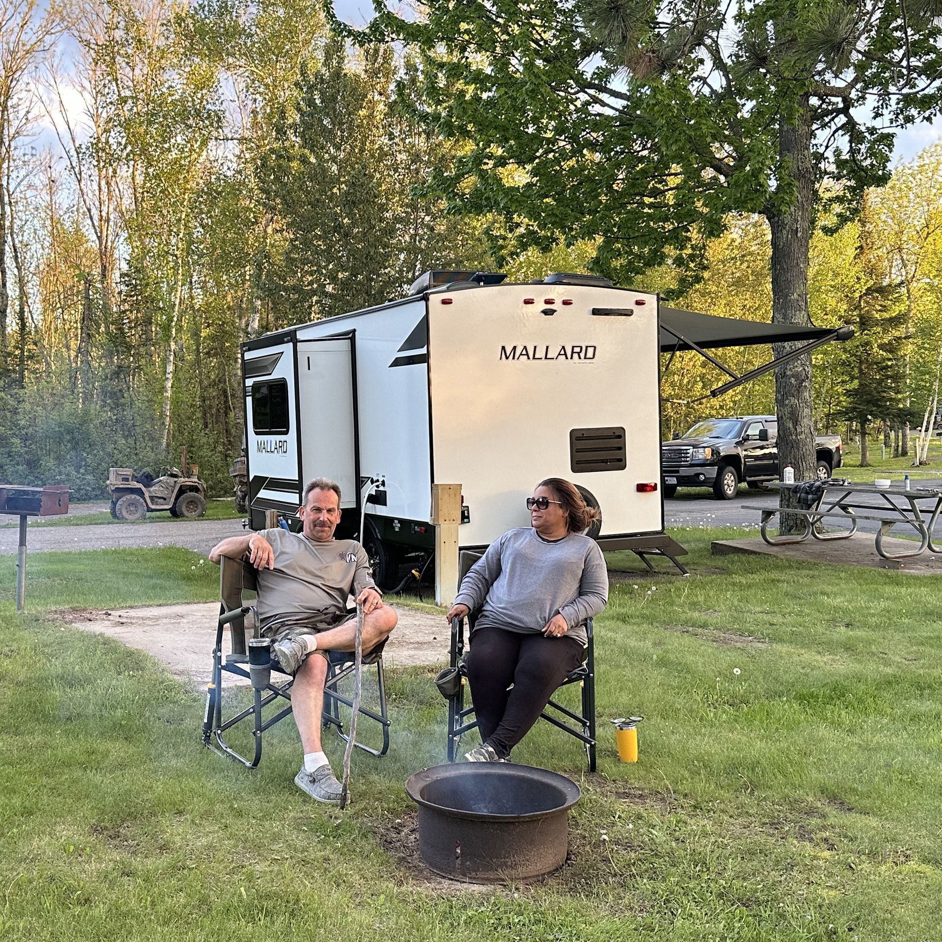 An image of a couple next to their RV at the Trails Inn Quadna Mountain Motel & RV Campground.