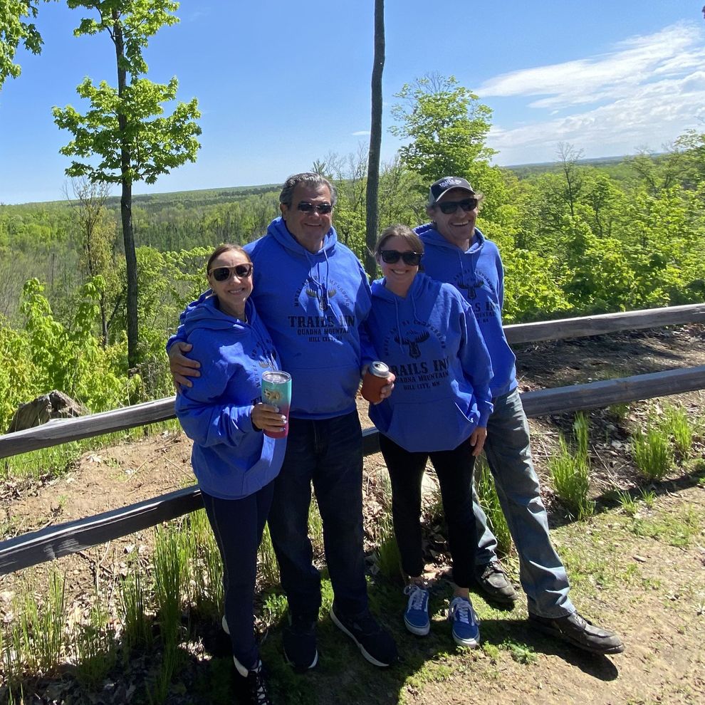 An image of a family standing on an ATV trail by the Hill City, MN Train Station.