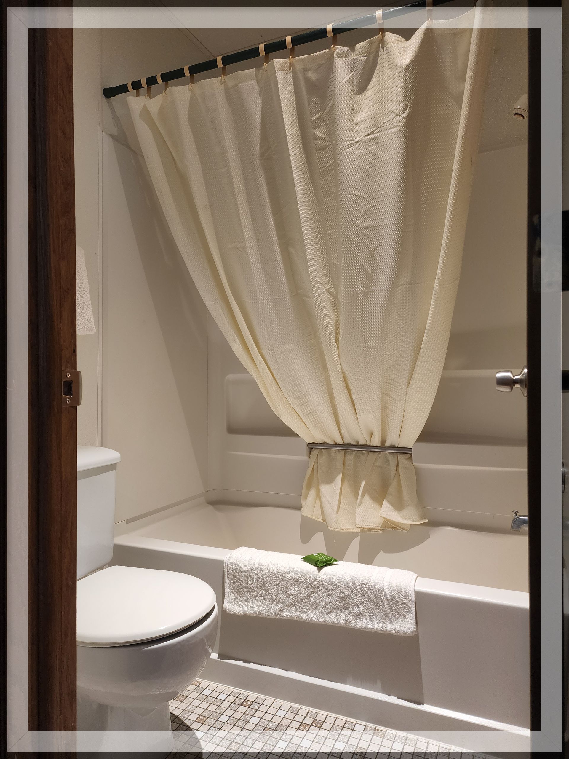 A Double Queen Room showing the bathroom, toilet, tub and shower curtain at Trails Inn Quadna Mountain Motel.