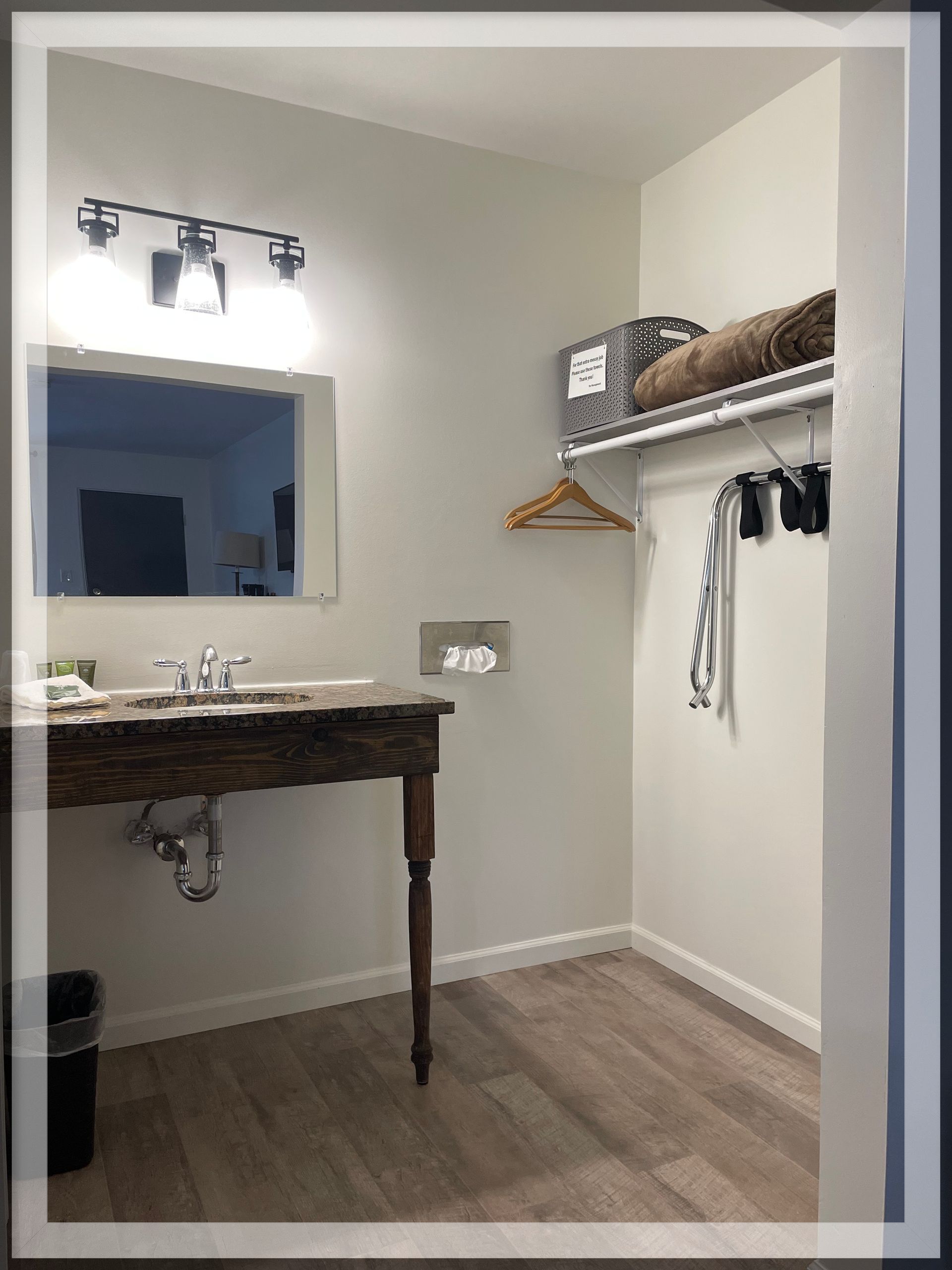 This is an image of the closet and bathroom vanity in a remodeled Double Queen Room at the Trails Inn Quadna Mountain Motel.