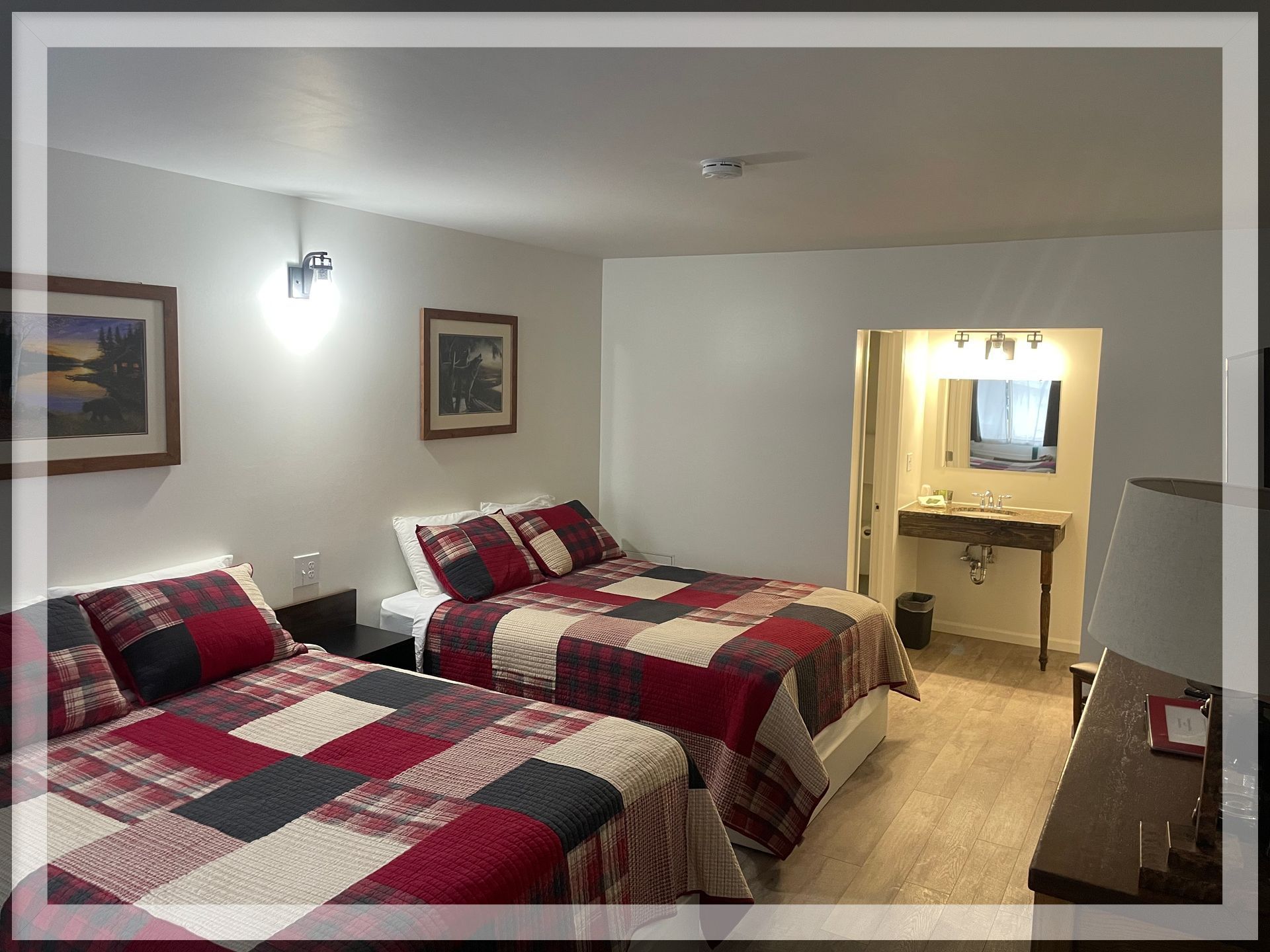 This is an image of the bedroom and bathroom entrance of a remodeled Double Queen Room.