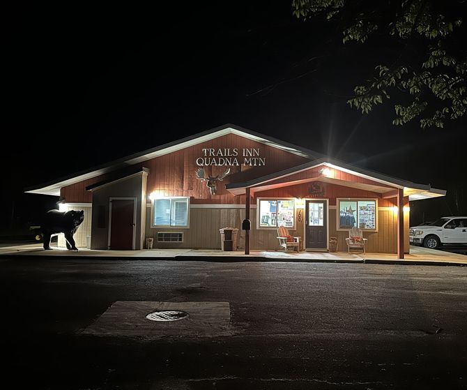 An image of the Trails Inn Quadna Motel & RV Campground office at night.