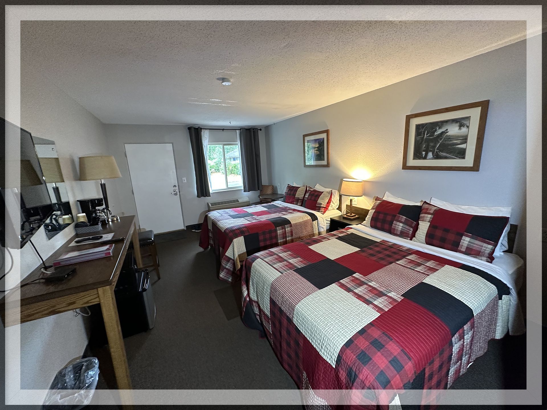 This is an image of the bedroom with the main window of a remodeled Double Queen Room.