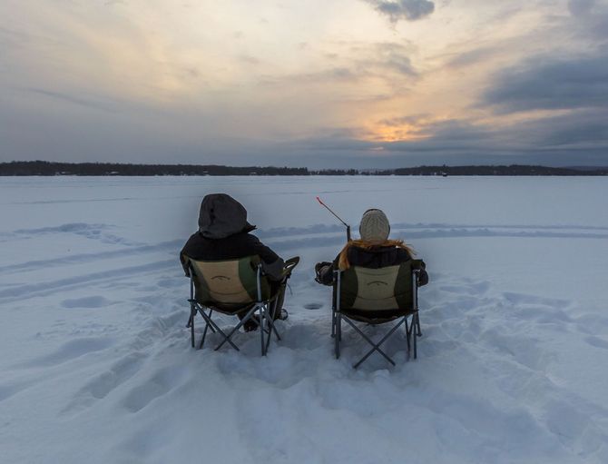 An image of 2 men ice fishing in Winter on Hill Lake in Hill City, MN.