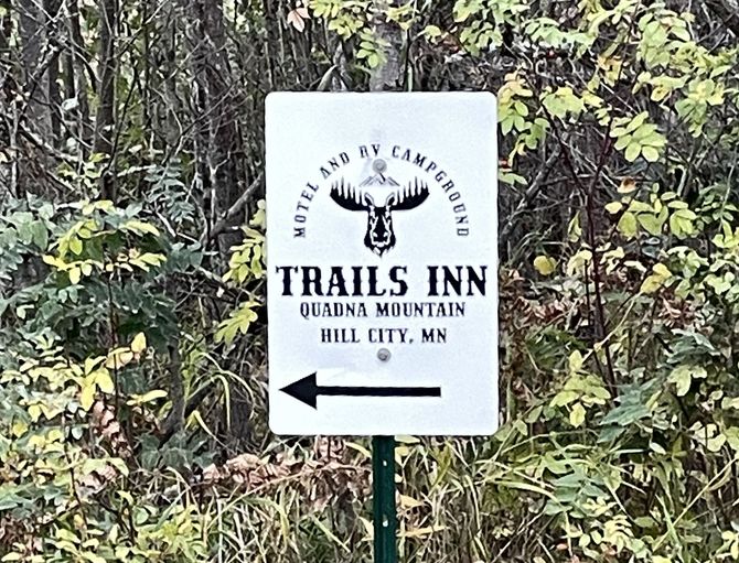 The trails sign with directional arrow for Trails Inn Quadna Mountain Motel and RV Campground in Hill City, MN.