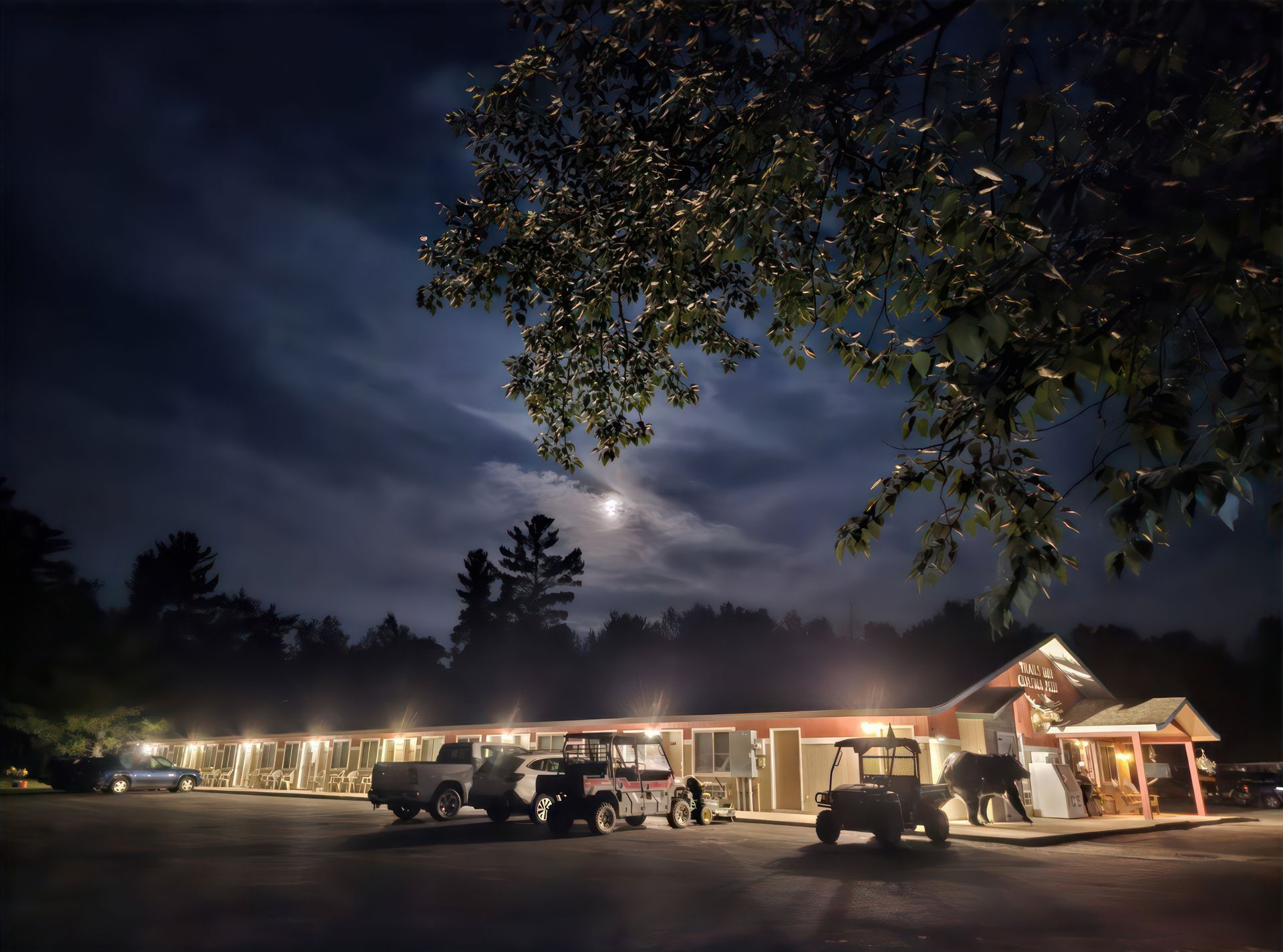 A moonlit night image of the Trails Inn Quadna Motel in Hill City, MN.