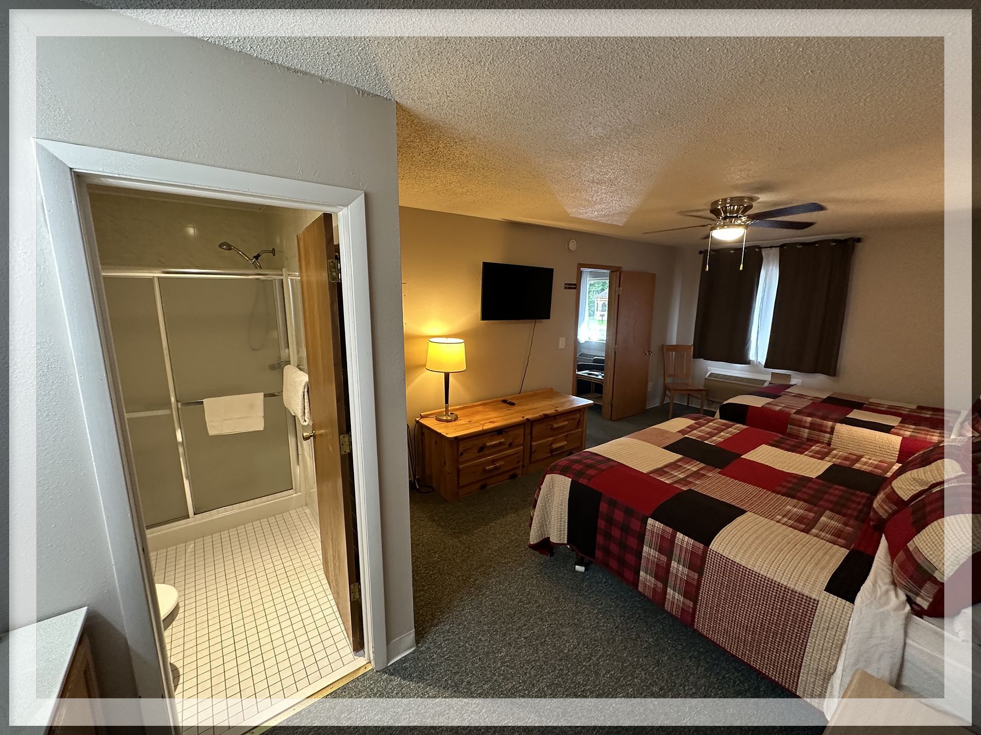 This is a bedroom and bathroom image of the 1 king bed, 1 queen bed, and 1 bathroom Extended Stay Suite.