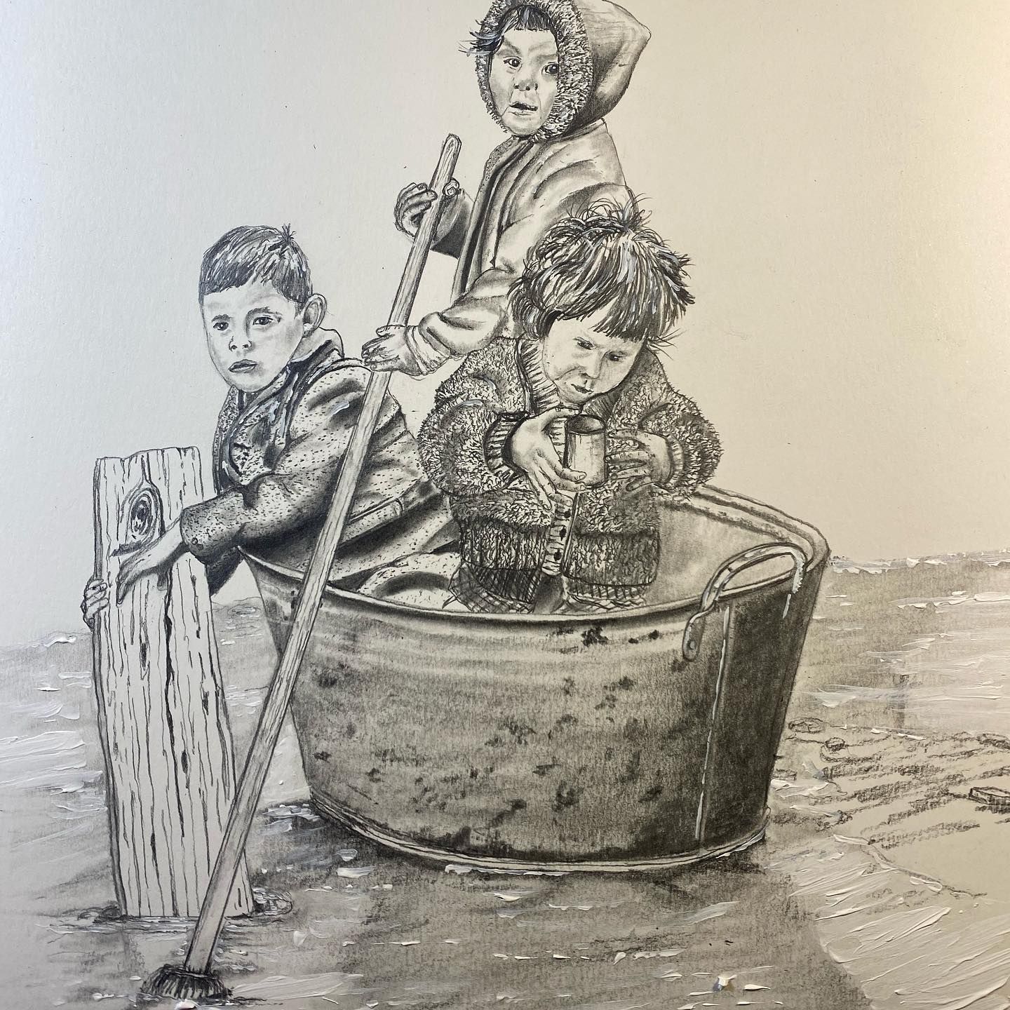 Three children in a metal tub on a beach, one pushing with a pole, others bundled.