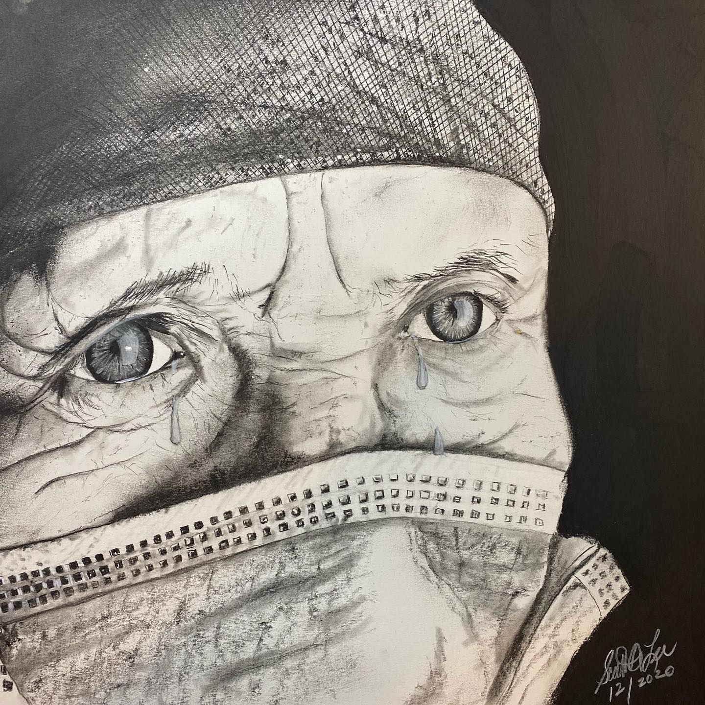 Close-up pencil drawing of a person wearing a mask and cap; eyes filled with water; dark background.