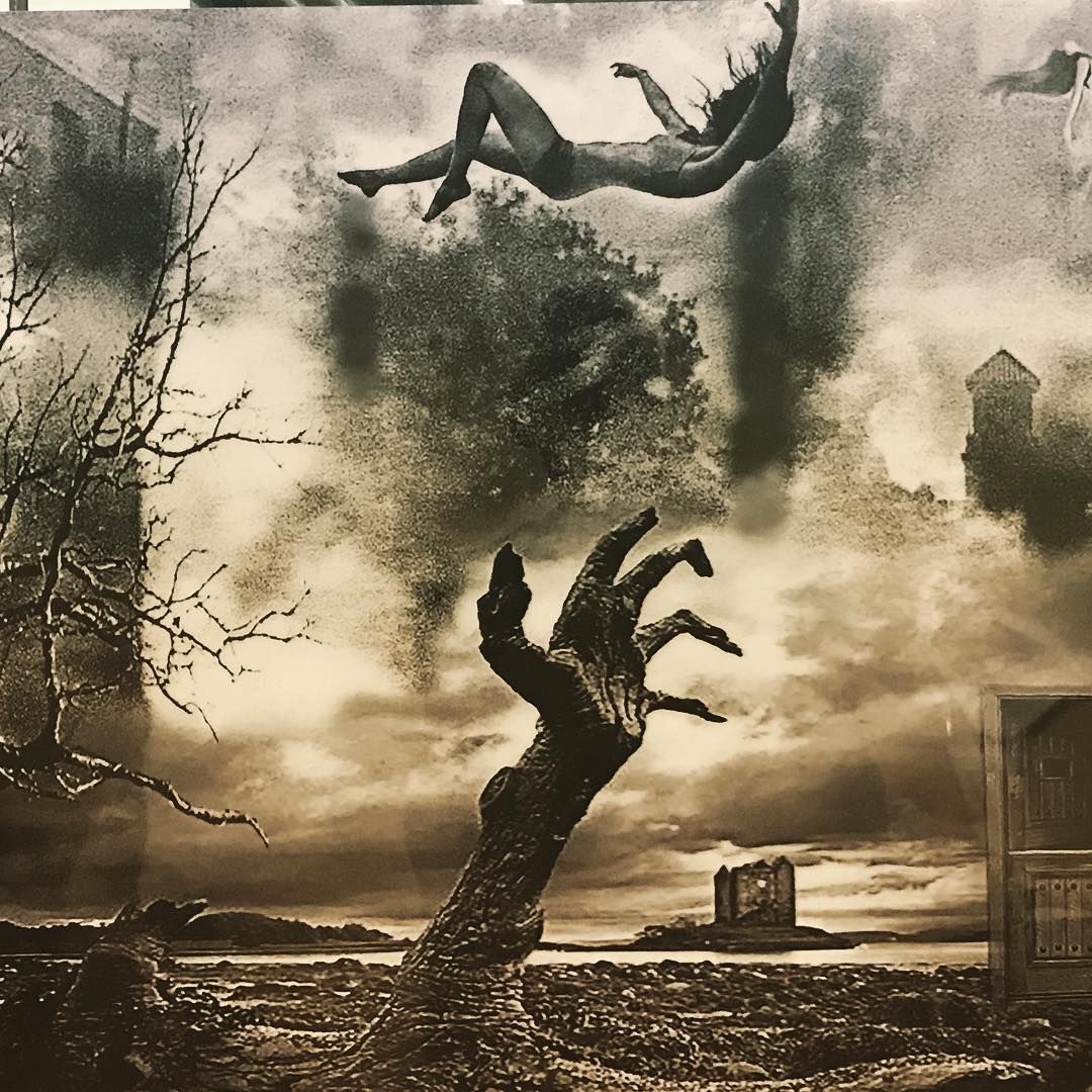 Woman falling, dark hand reaching up, ominous landscape with castle ruins.