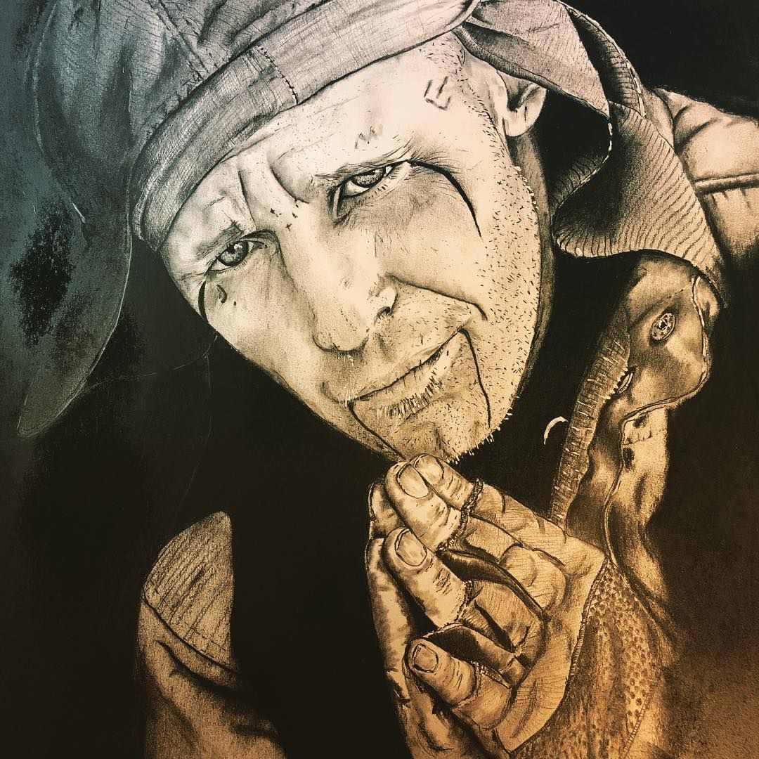 Jester with somber expression, hands clasped, wearing a hat with bells, against a dark background.