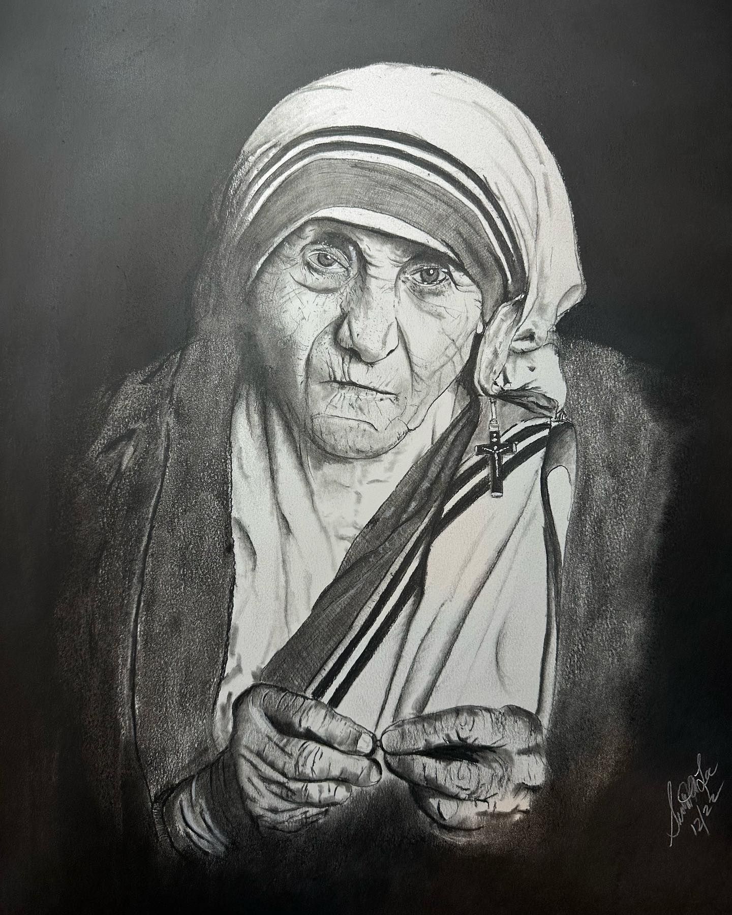 Portrait of Mother Teresa in black and white, wearing her traditional habit, looking intently forward.
