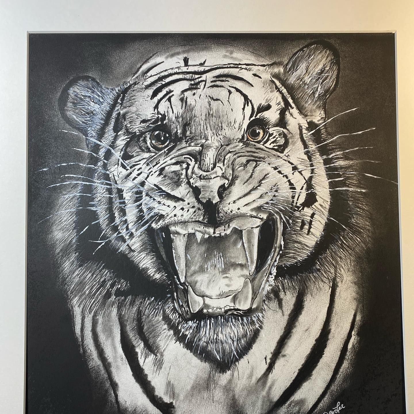 Black and white drawing of a tiger snarling, with exposed teeth and detailed fur texture.