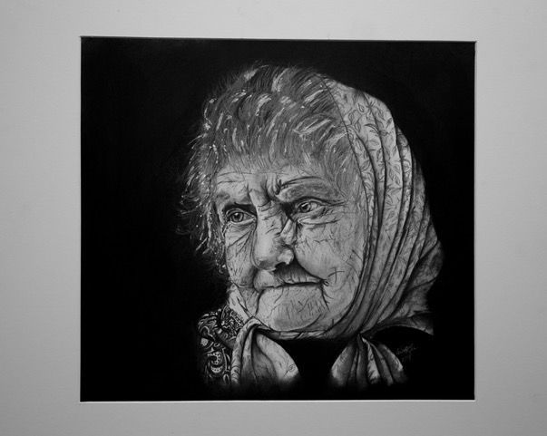 Portrait of an elderly person wearing a headscarf, rendered in grayscale.