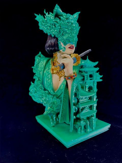 Green sculpture of woman with ornate headwear and pagoda.